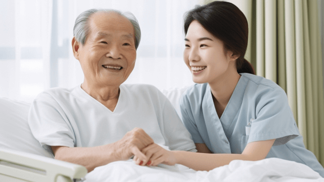体を起こす高齢男性を支える女性介護士