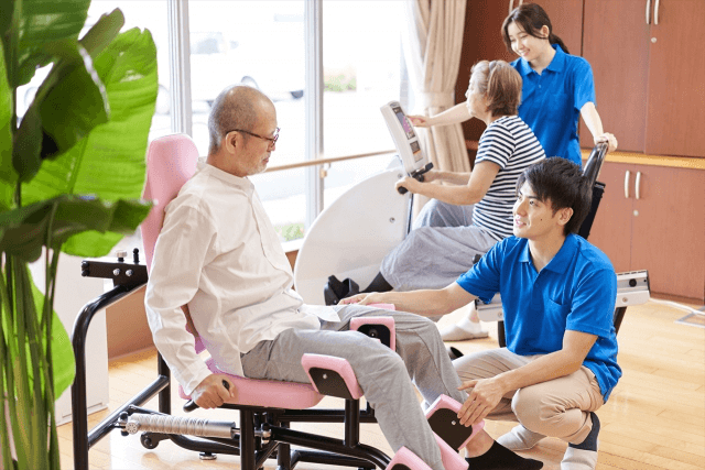 高齢男性のトレーニングをサポートする男性介護士