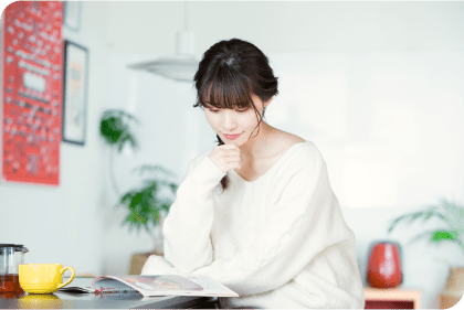 �e�[�u���ɍ����ĕ����̎������r�������Ă��锒���Z�[�^�[�̏����B�R�[�q�[�J�b�v�ƃX�}�[�g�t�H�����u����A�W�����ču���I�т����Ă���l�q